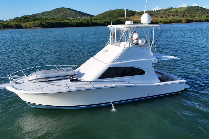  Yacht Photos Pics 2005 Luhrs 38 Convertible yacht cruising on calm waters with scenic background.