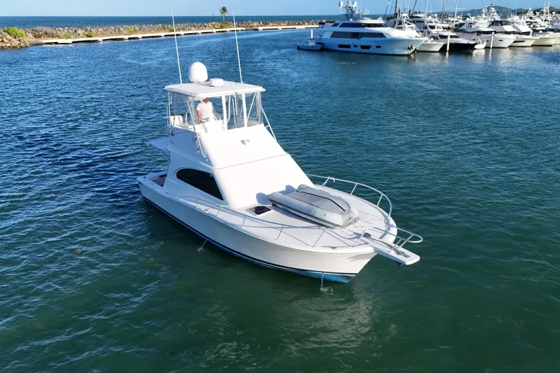  Yacht Photos Pics 2005 Luhrs 38 Convertible yacht in a marina, surrounded by water and other boats.