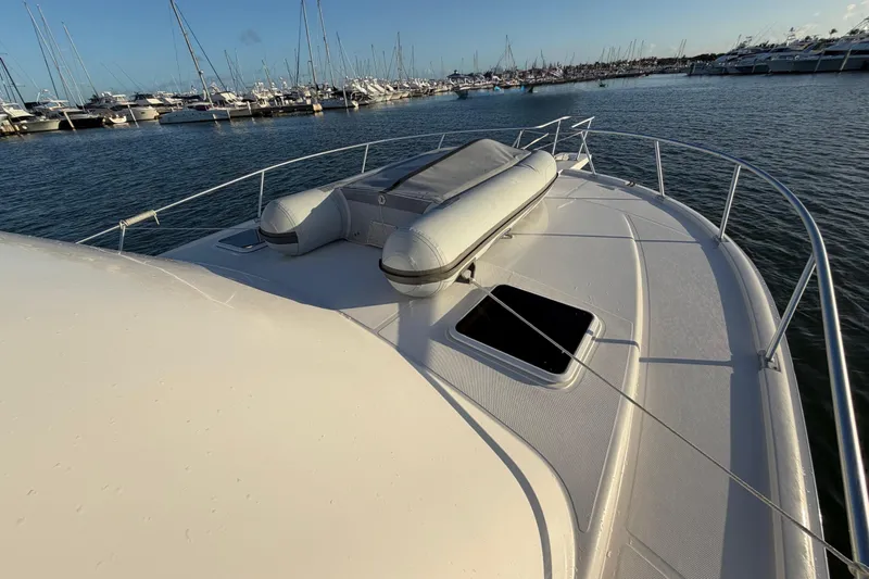  Yacht Photos Pics 2005 Luhrs 38 Convertible yacht with inflatable boat on deck, docked in marina.