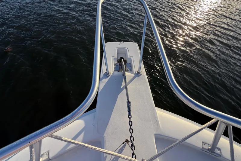  Yacht Photos Pics Bow view of 2005 Luhrs 38 Convertible boat with anchor chain over water.