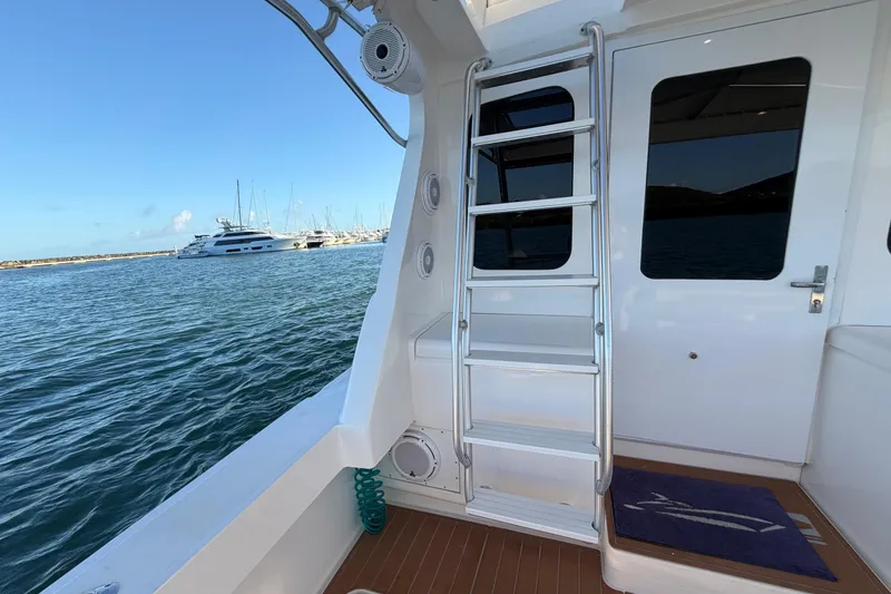  Yacht Photos Pics 2005 Luhrs 38 Convertible yacht with ladder, docked in a marina.