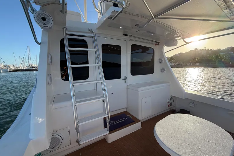  Yacht Photos Pics 2005 Luhrs 38 Convertible yacht deck with ladder, table, and marina view at sunset.