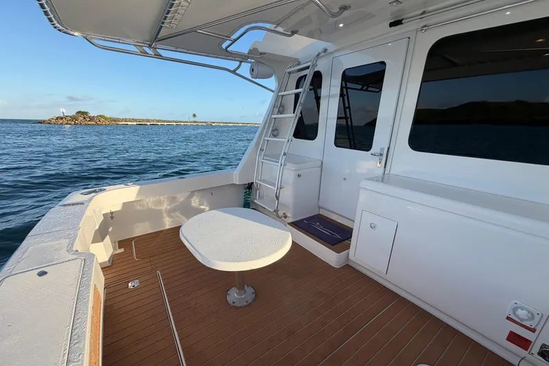  Yacht Photos Pics 2005 Luhrs 38 Convertible yacht deck with table, overlooking serene ocean view.