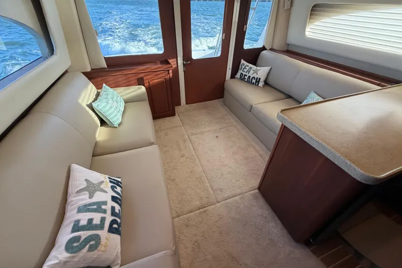  Yacht Photos Pics Interior of 2005 Luhrs 38 Convertible yacht with beige seating and sea-themed pillows.