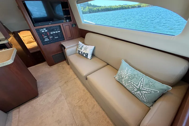  Yacht Photos Pics Interior of 2005 Luhrs 38 Convertible yacht with sofa, pillows, and scenic window view.