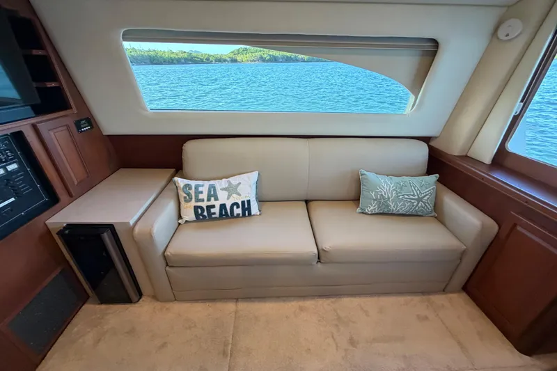  Yacht Photos Pics Interior of 2005 Luhrs 38 Convertible yacht with beige sofa and sea-themed pillows.