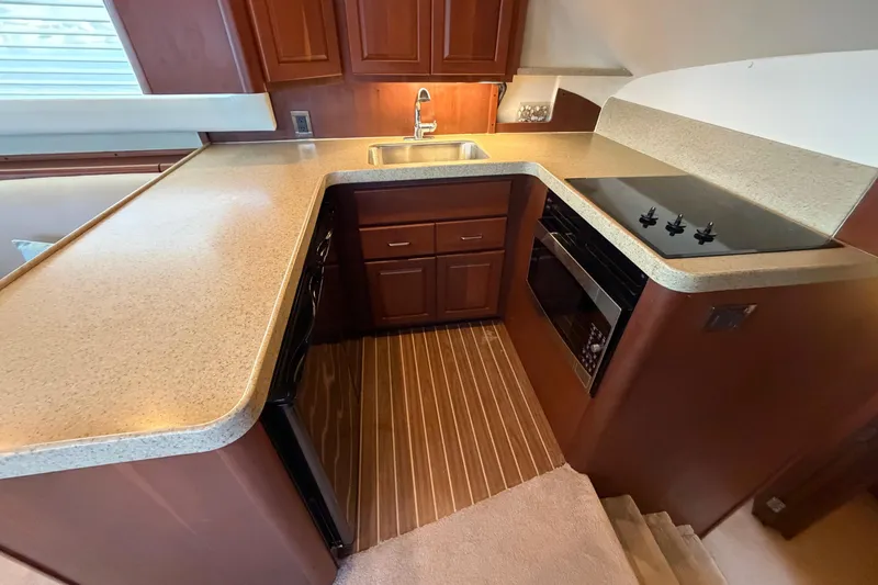 Yacht Photos Pics 2005 Luhrs 38 Convertible yacht kitchen with modern appliances and wooden cabinetry.