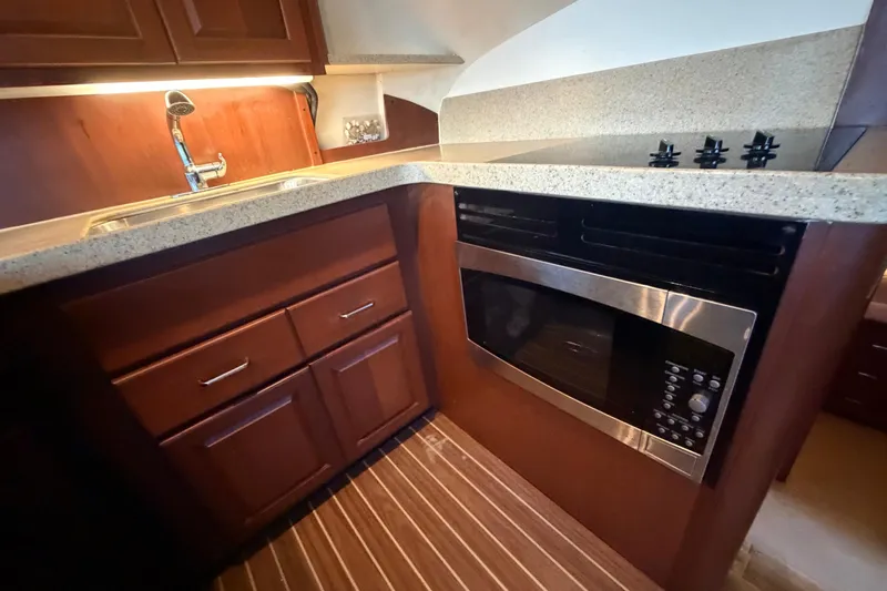  Yacht Photos Pics 2005 Luhrs 38 Convertible yacht kitchen with wood cabinets and modern appliances.