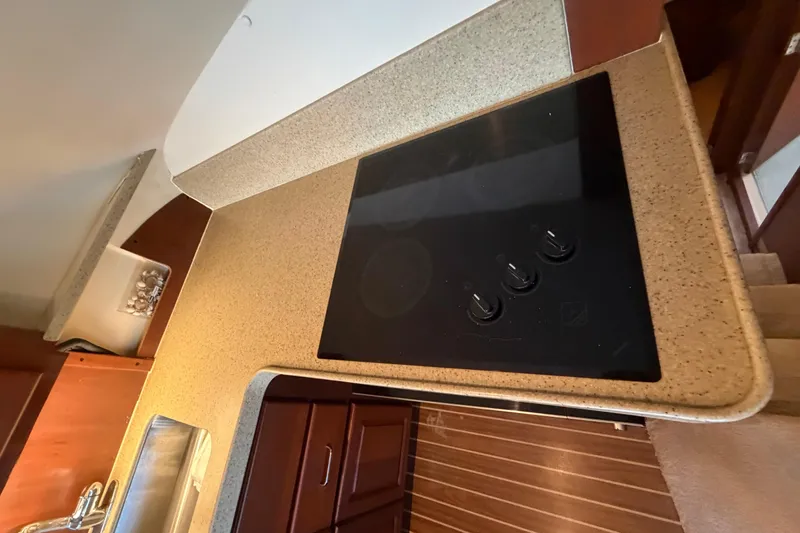  Yacht Photos Pics 2005 Luhrs 38 Convertible kitchen with electric cooktop and wooden cabinetry.