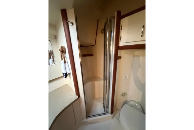  Yacht Photos Pics 2005 Luhrs 38 Convertible yacht bathroom with shower, toilet, and storage cabinets.