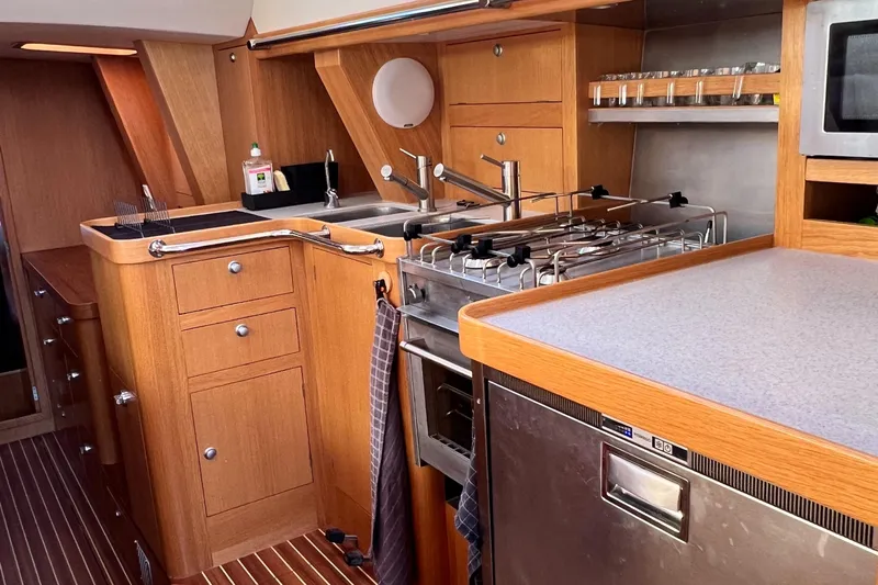 Maquis Yacht Photos Pics Modern kitchen interior of 2020 Boreal 55 OC yacht with wooden cabinetry and stainless steel appliances.