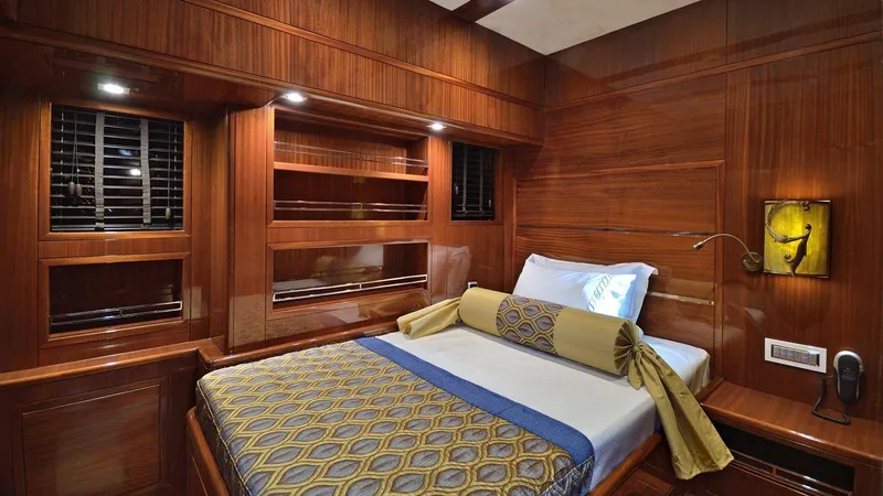  Yacht Photos Pics Luxurious wooden cabin interior of a 2012 Custom Motorsailor with elegant bedding and ambient lighting.