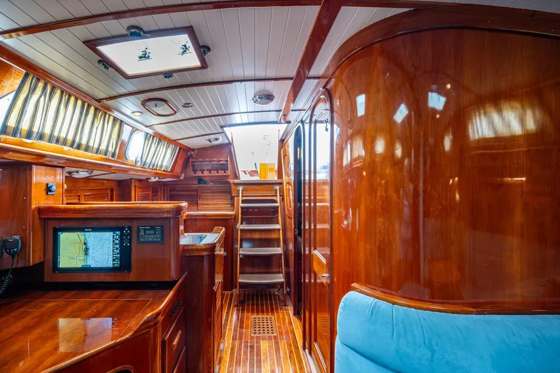 Ghost Yacht Photos Pics Luxurious interior of 2000 Hinckley Sou'wester Stoway Sloop with polished wood and navigation equipment.