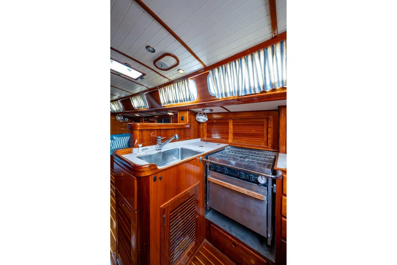 Ghost Yacht Photos Pics Hinckley Sou'wester Stoway Sloop 2000 interior kitchen with wood finish and modern appliances.