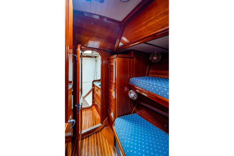 Ghost Yacht Photos Pics Hinckley Sou'wester Stoway Sloop 2000 interior with wooden finish and blue star-patterned bunks.
