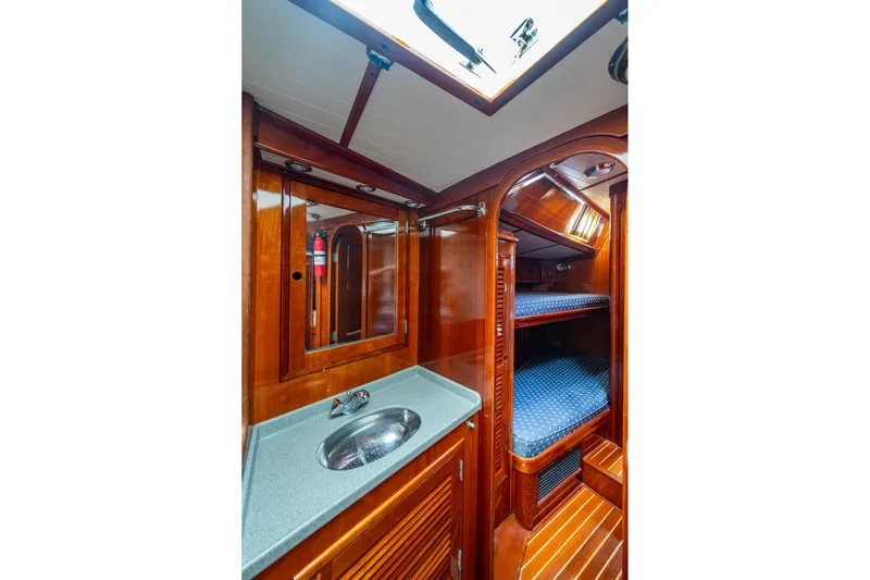 Ghost Yacht Photos Pics Hinckley Sou'wester Stoway Sloop 2000 interior with wooden cabinetry, sink, and bunk beds.