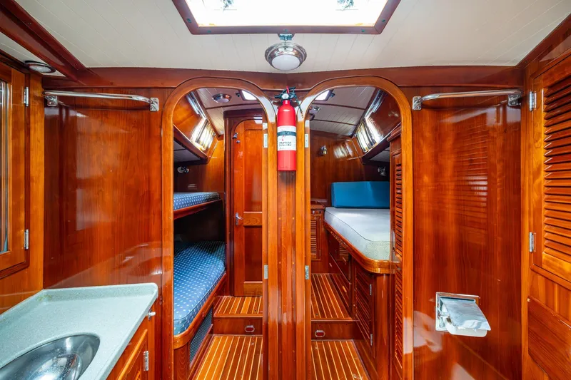 Ghost Yacht Photos Pics Luxurious 2000 Hinckley Sou'wester Stoway Sloop interior with polished wood and cozy bunks.