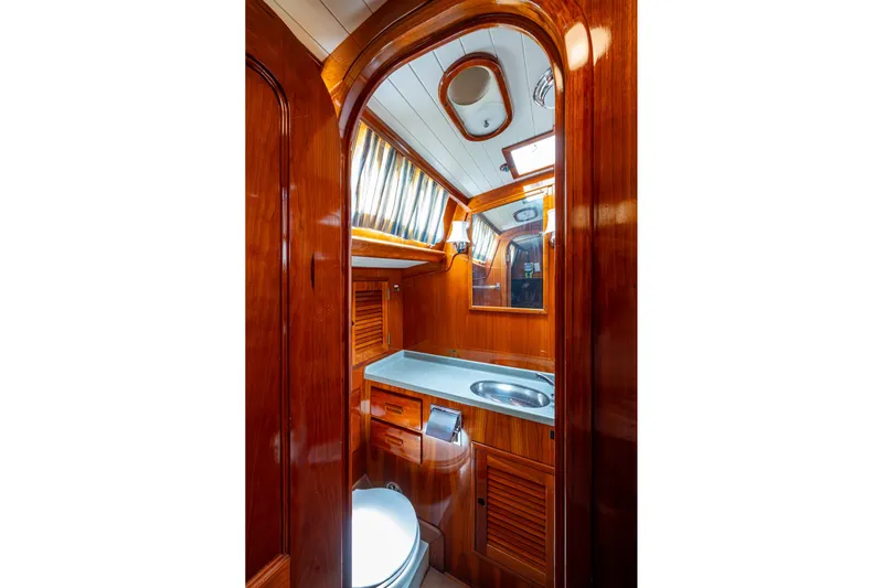 Ghost Yacht Photos Pics Luxurious wooden interior of 2000 Hinckley Sou'wester Stoway Sloop bathroom with sink and mirror.