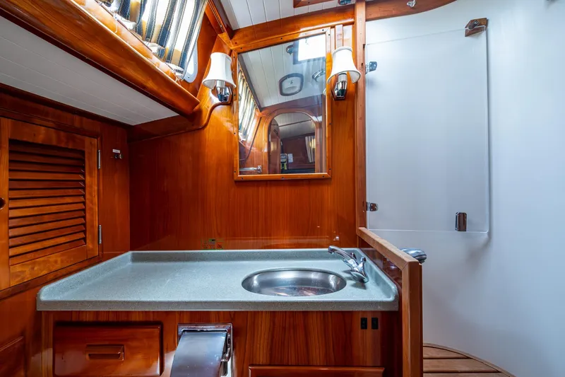 Ghost Yacht Photos Pics Hinckley Sou'wester Stoway Sloop 2000 bathroom with wooden cabinetry and modern fixtures.