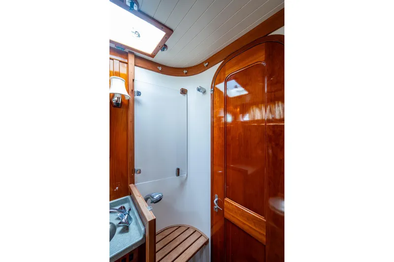 Ghost Yacht Photos Pics Hinckley Sou'wester Stoway Sloop 2000 bathroom with wooden finishes and modern fixtures.