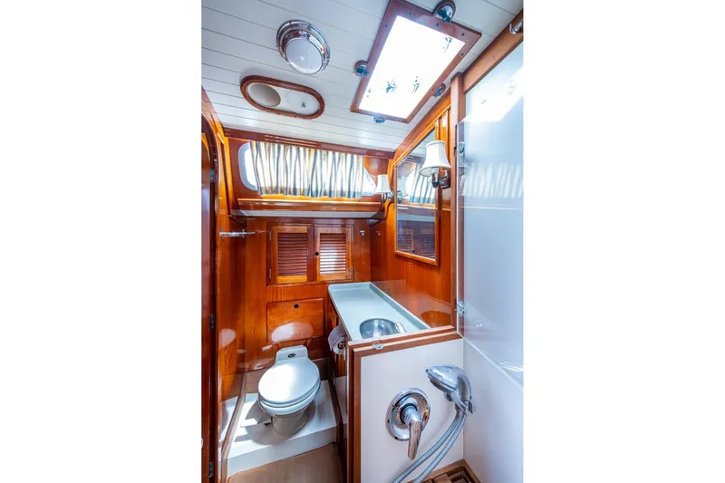 Ghost Yacht Photos Pics Hinckley Sou'wester Stoway Sloop 2000 yacht bathroom with wooden cabinetry and modern fixtures.