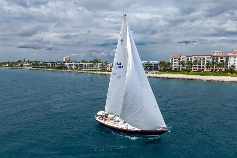 Ghost Yacht Photos Pics Hinckley Sou'wester Stoway Sloop sailing near coastal buildings under cloudy skies, 2000 model.
