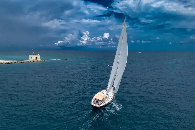 Ghost Yacht Photos Pics Sailing yacht Hinckley Sou'wester Stoway Sloop 2000 on open sea under dramatic sky.