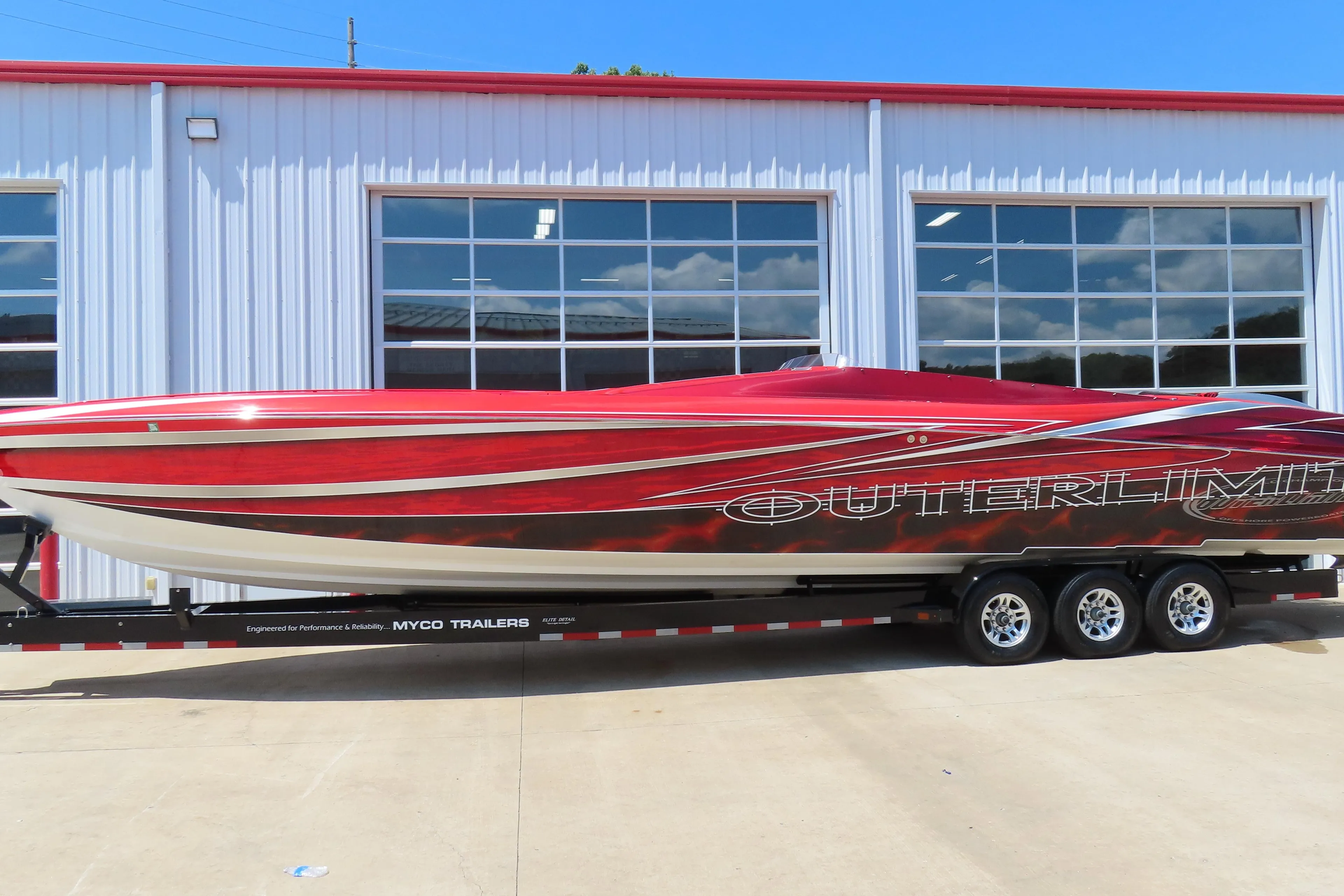 2004 Outerlimits 42 Legacy speedboat on trailer, vibrant red and white design.