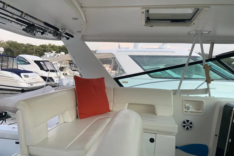  Yacht Photos Pics 2002 Tiara Yachts 4100 Open interior with white seating and red cushion, docked at marina.