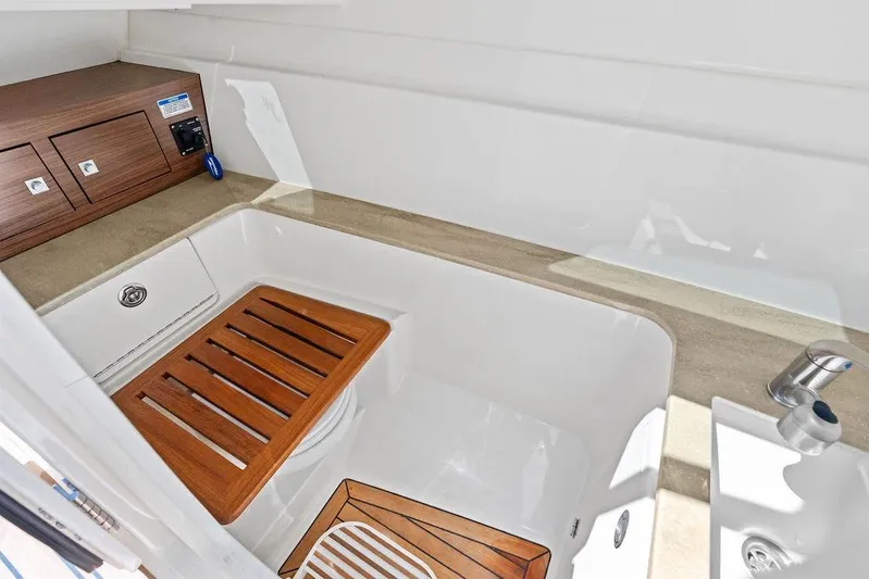Marmara Yacht Photos Pics 2020 Boston Whaler 320 Vantage boat interior with wooden seat and storage.