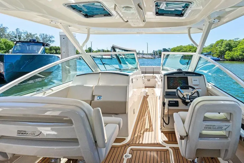 Marmara Yacht Photos Pics 2020 Boston Whaler 320 Vantage boat interior with helm and seating, docked on a sunny day.