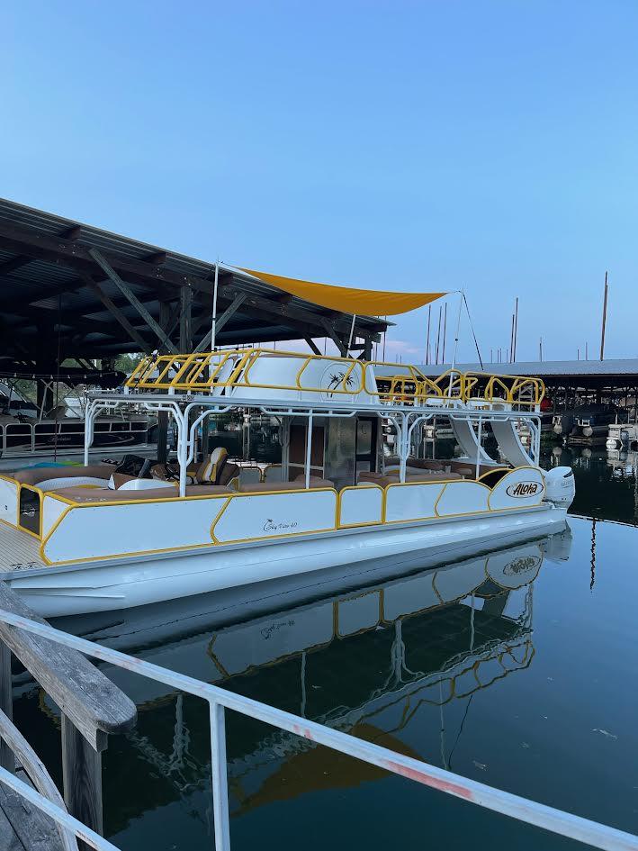 2025 Aloha Pontoon 40' Sky View boat docked at marina with yellow accents.