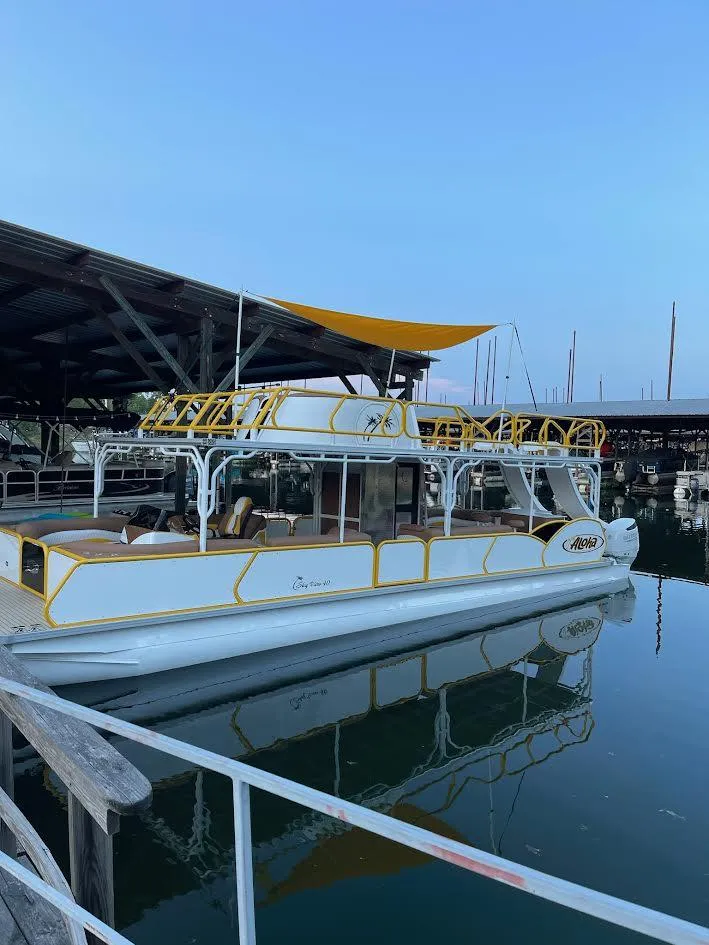 2025 Aloha Pontoon 40' Sky View boat docked at marina with yellow accents.
