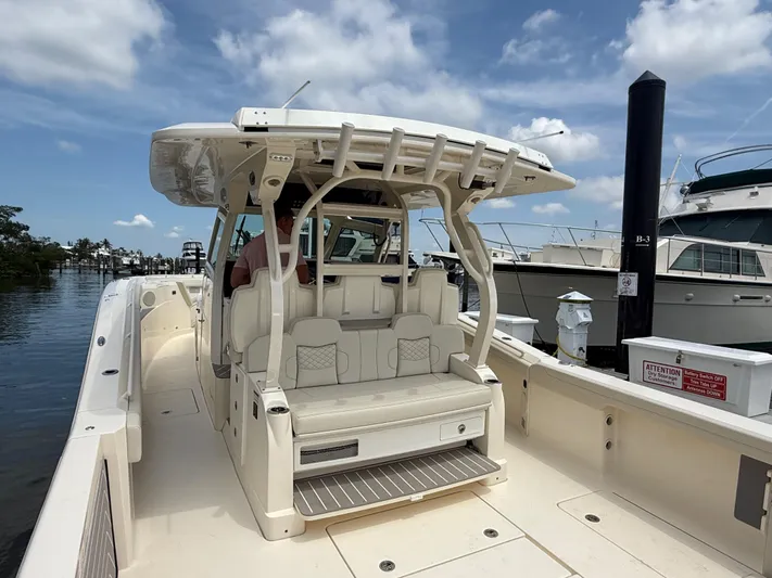  Yacht Photos Pics 2025 Scout 400 LXF boat docked, featuring spacious seating and sleek design under a clear sky.