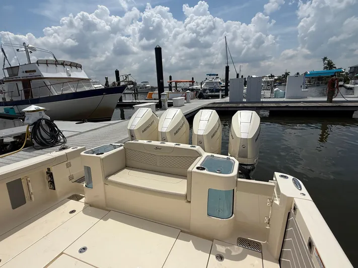  Yacht Photos Pics 2025 Scout 400 LXF boat docked, featuring four Mercury outboard engines under a cloudy sky.