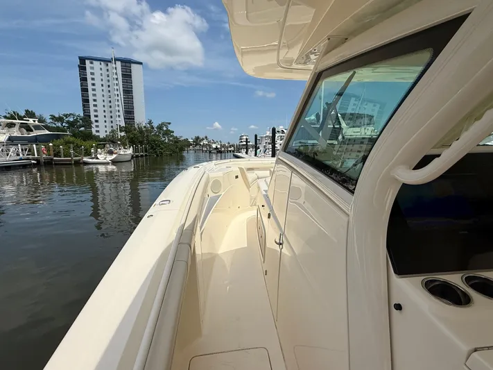  Yacht Photos Pics 2025 Scout 400 LXF boat docked in a marina with modern buildings in the background.