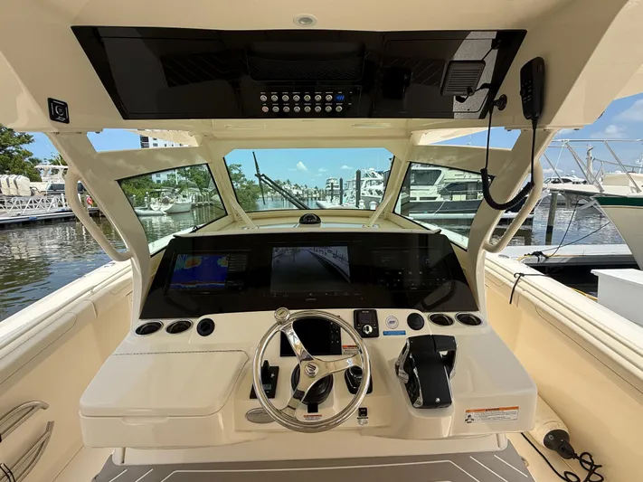  Yacht Photos Pics 2025 Scout 400 LXF boat helm with advanced navigation system and steering wheel.
