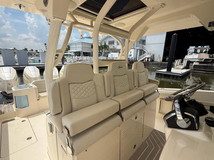  Yacht Photos Pics 2025 Scout 400 LXF boat interior with luxurious seating and helm, docked at marina.