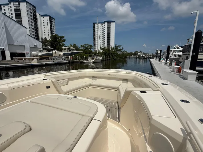  Yacht Photos Pics 2025 Scout 400 LXF boat docked at marina with modern buildings in background.
