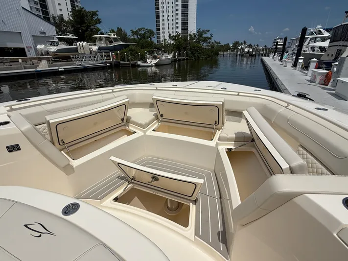  Yacht Photos Pics 2025 Scout 400 LXF boat interior with open storage compartments at a marina.