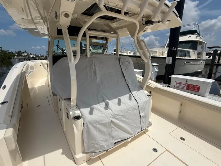  Yacht Photos Pics 2025 Scout 400 LXF boat interior with covered seating, docked at marina under clear sky.