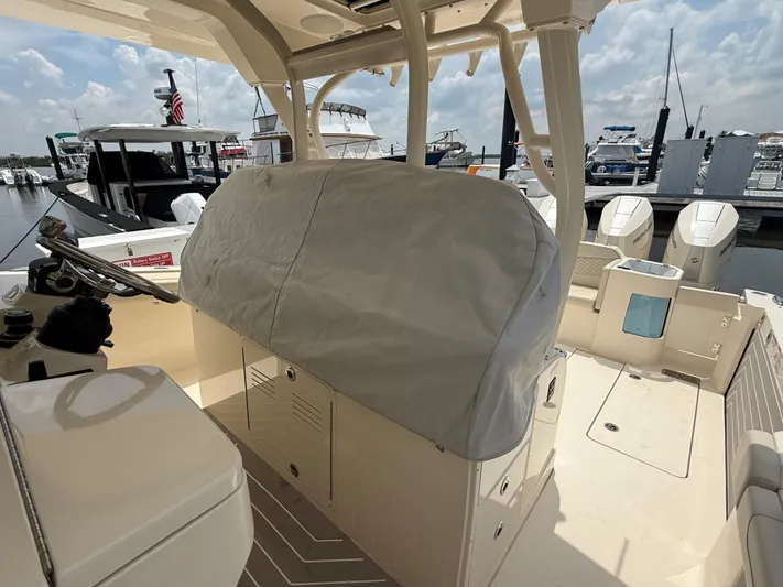  Yacht Photos Pics 2025 Scout 400 LXF boat interior at marina, featuring covered console and multiple outboard engines.