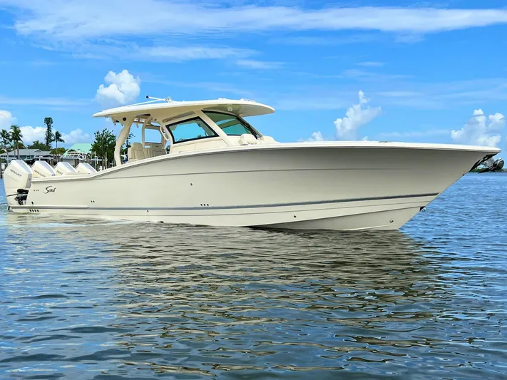  Yacht Photos Pics 2025 Scout 400 LXF luxury boat on calm water under blue sky.