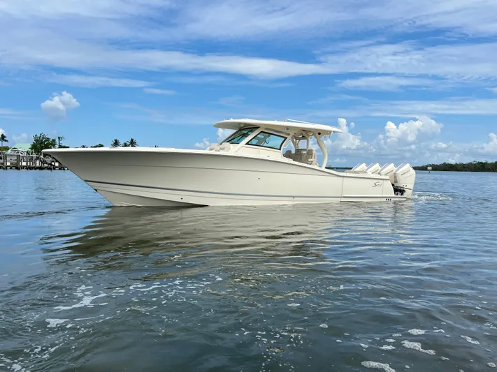  Yacht Photos Pics 2025 Scout 400 LXF boat on calm water under a blue sky.