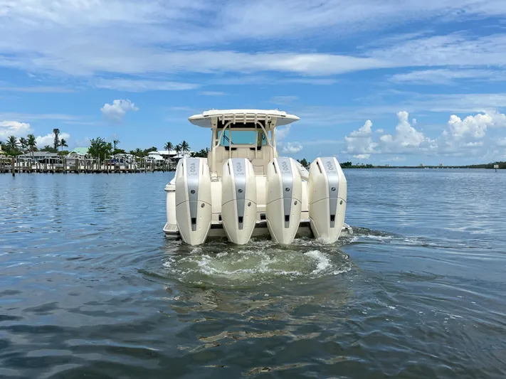  Yacht Photos Pics 2025 Scout 400 LXF boat with multiple engines on a calm waterway.