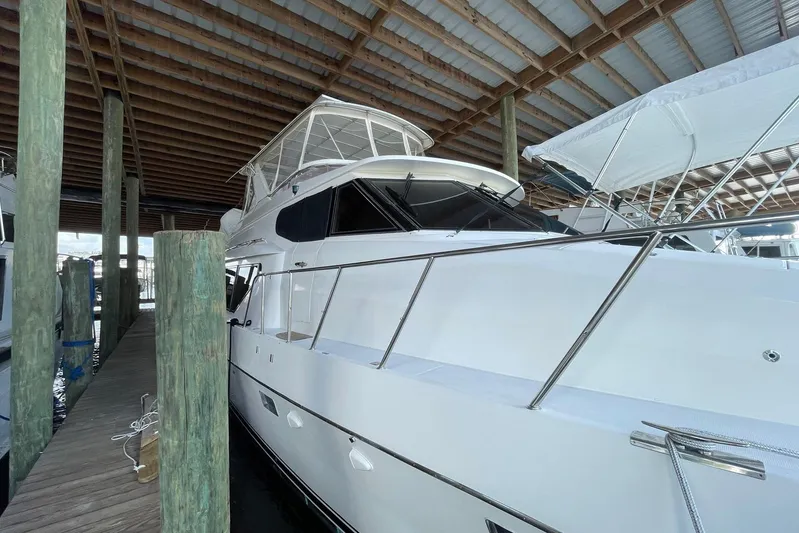 Aventis Yacht Photos Pics 1999 McKinna 57 Pilothouse yacht docked under a wooden shelter.