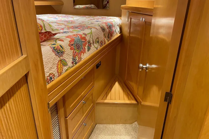 Aventis Yacht Photos Pics Cozy cabin interior of 1999 McKinna 57 Pilothouse with floral bedding and wooden cabinetry.