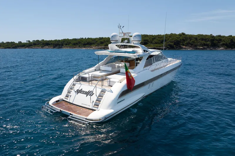  Yacht Photos Pics Luxury 2006 Mangusta 80 yacht cruising on blue ocean near lush coastline.