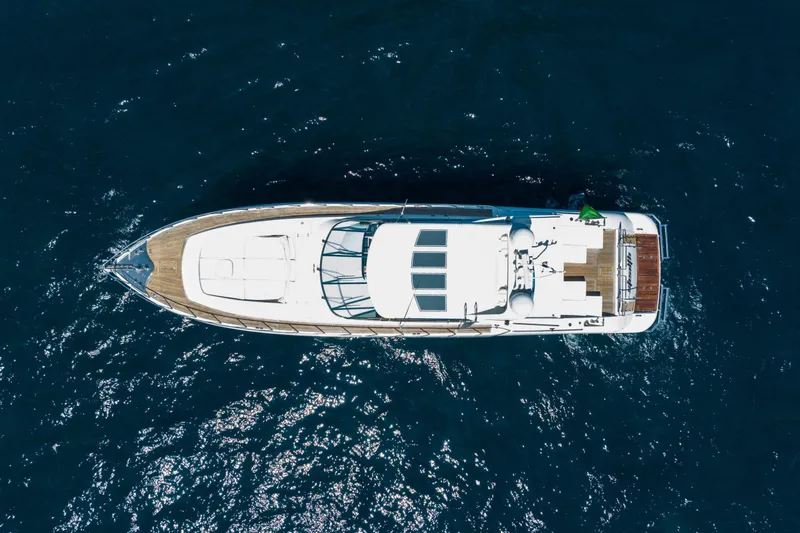  Yacht Photos Pics Aerial view of 2006 Mangusta 80 yacht cruising on deep blue ocean waters.