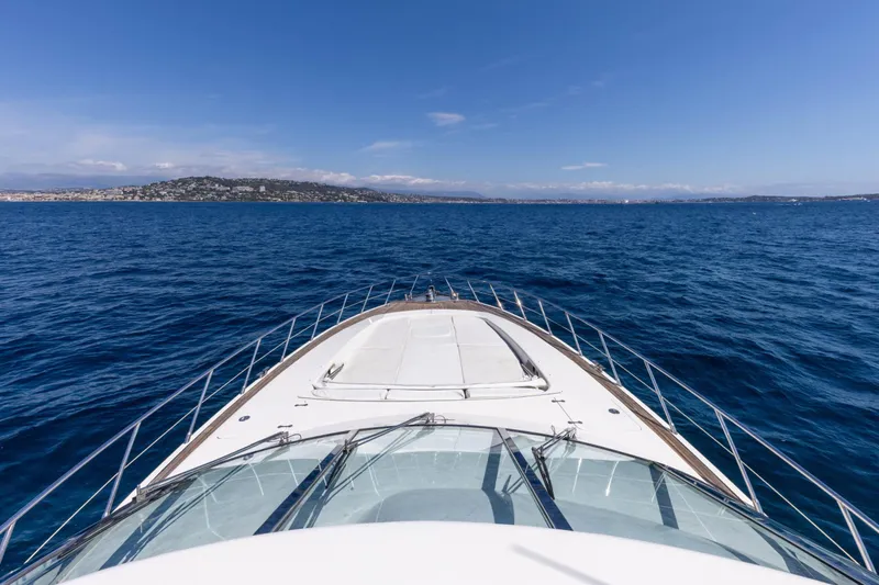  Yacht Photos Pics Front view of 2006 Mangusta 80 yacht cruising on open sea under clear blue sky.